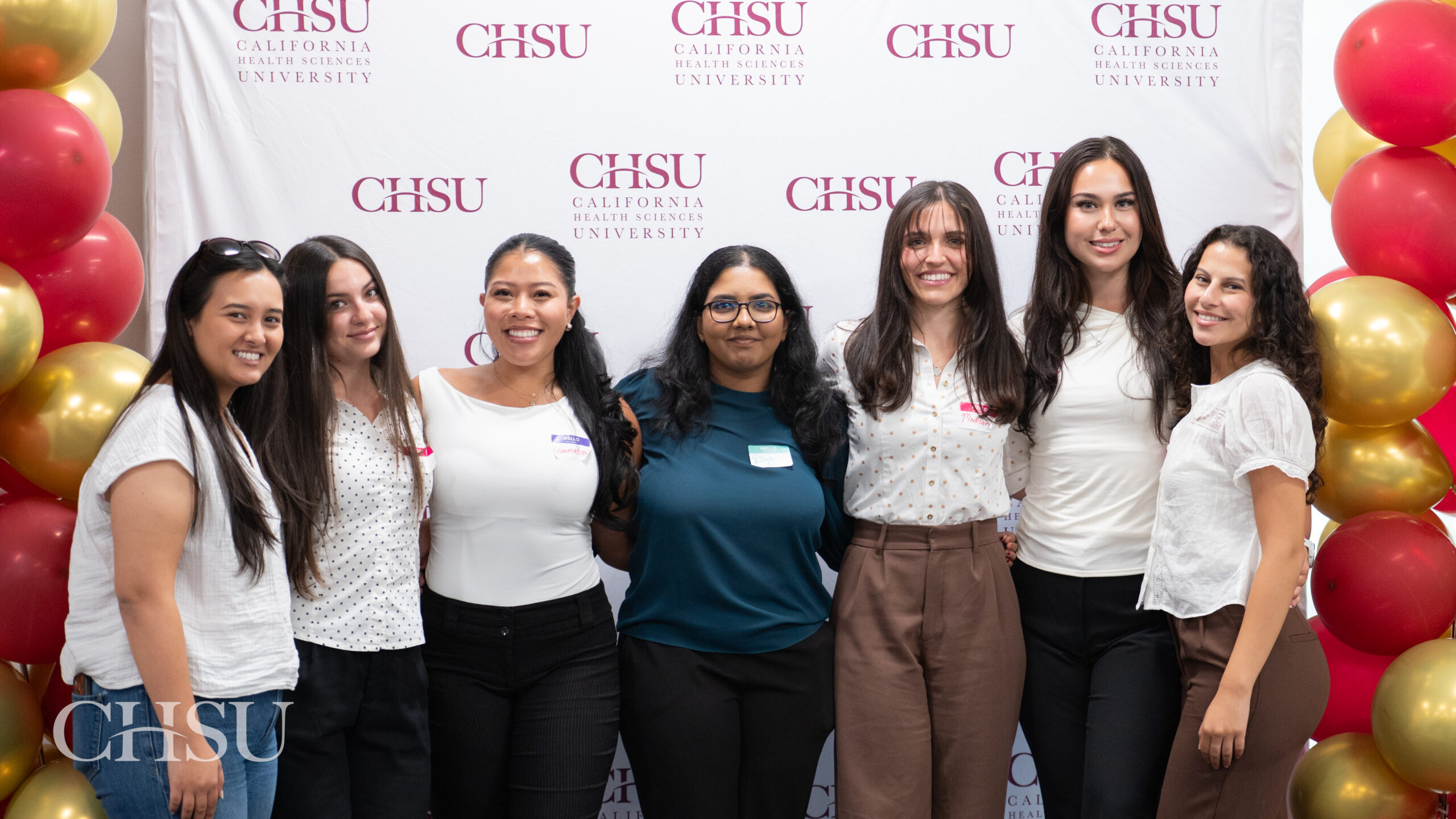 Seven incoming CHSU MSBS Class of 2027 students pose together in front of a California Health Sciences University backdrop during orientation.