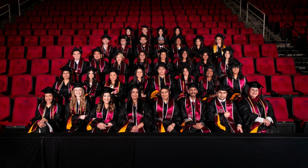 MSBS Class 2026 Group Photo in regalia, seated in stadium