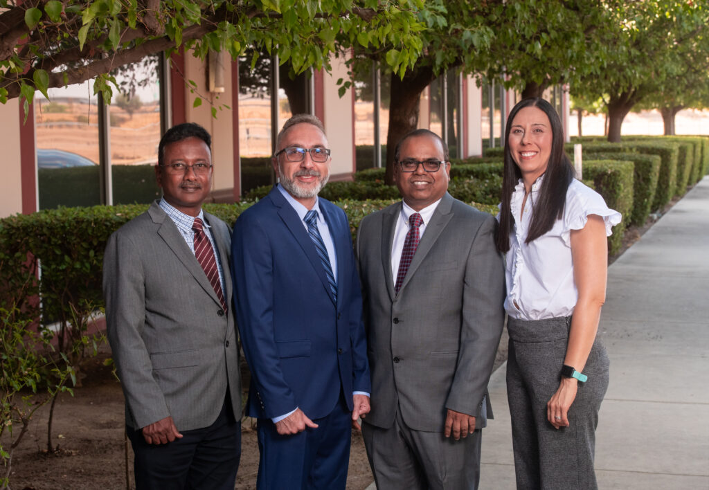 faculty and dean in front of building with trees